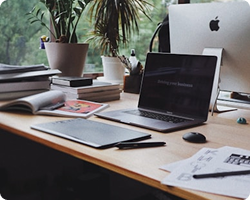 Laptop workspace with notebooks on a desk