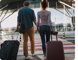 Travelers walking through an airport with luggage